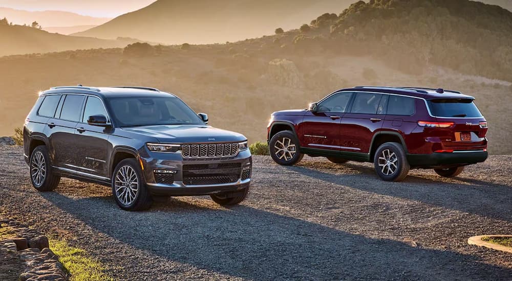 A grey and a red 2024 Jeep Grand Cherokee parked during a sunset.
